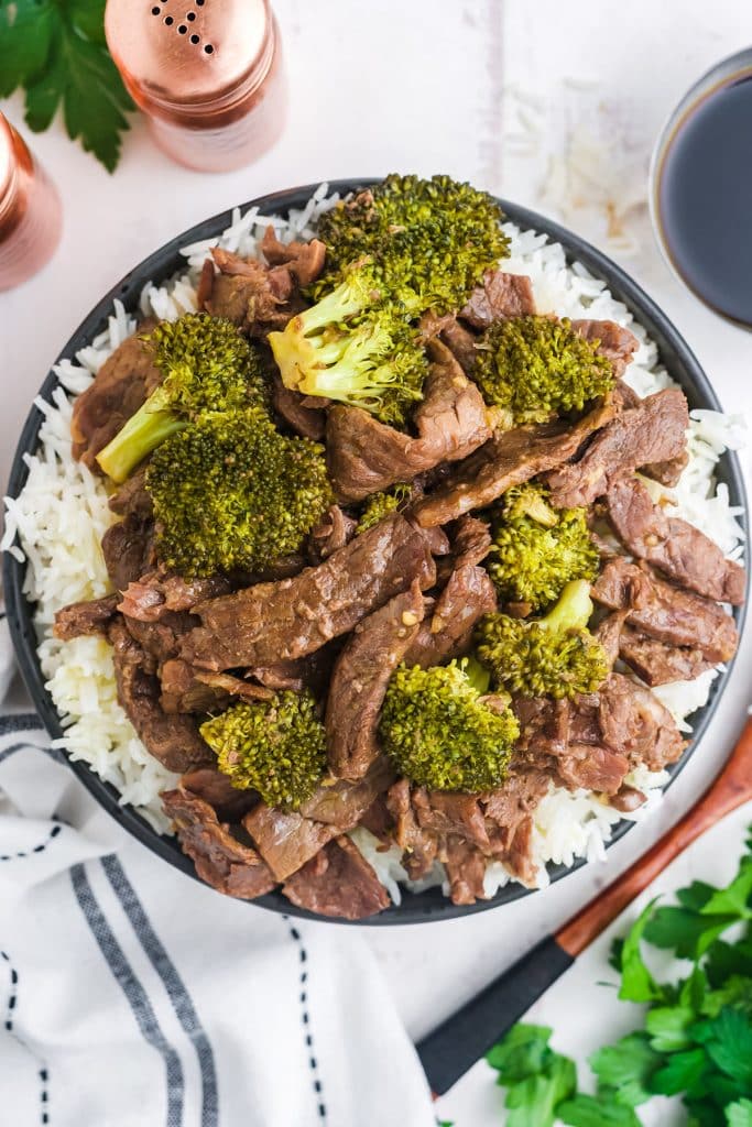overhead shot of a bowl of rice topped with beef and broccoli.