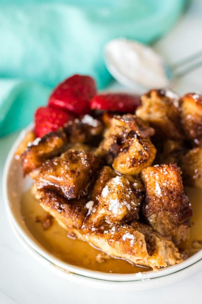 plate of french toast casserole topped with syrup.