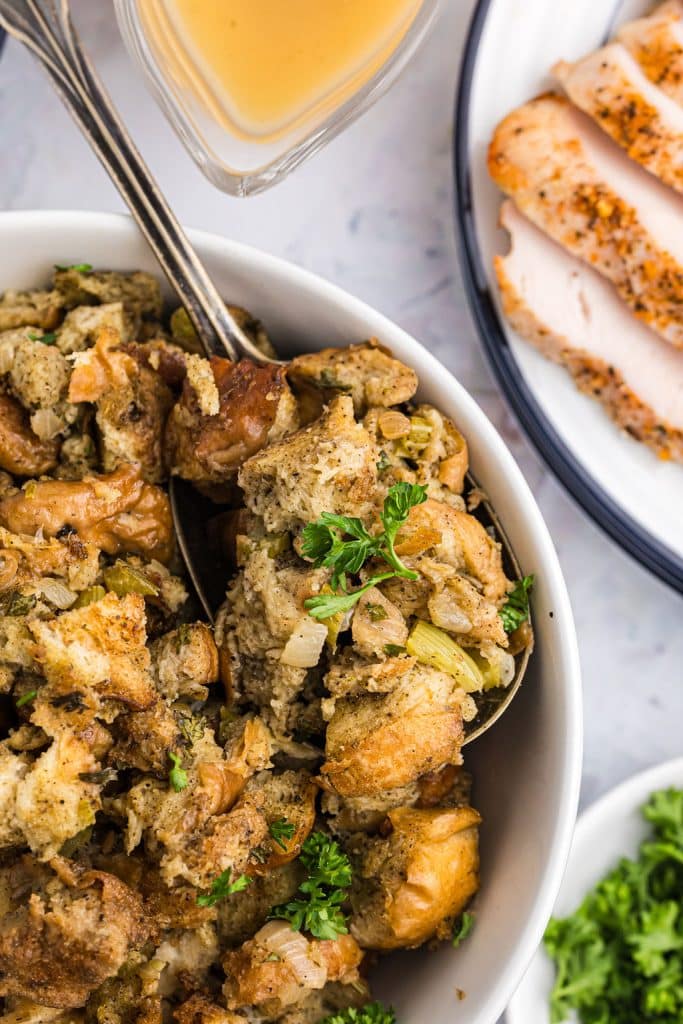 serving platter of stuffing with a spoon in it.