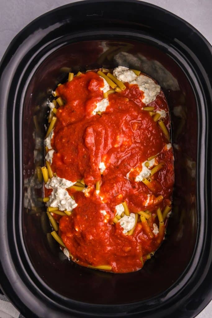 overhead shot of pasta sauce in a black slow cooker.