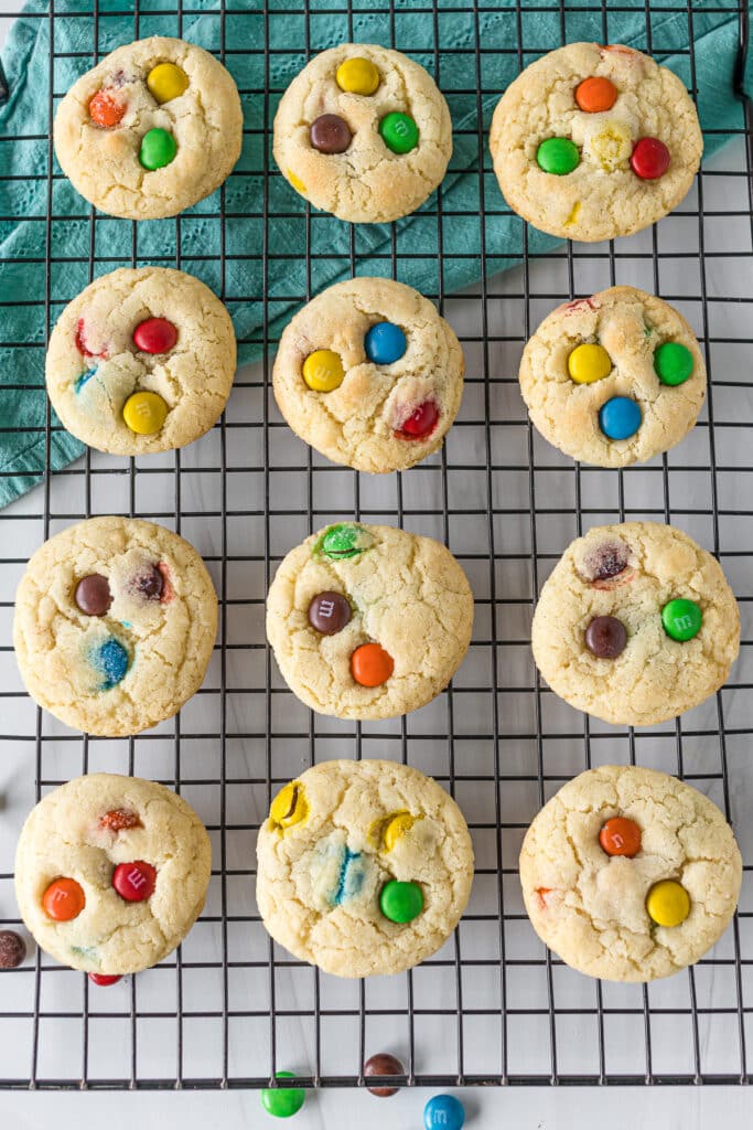 overhead shot of m&M sugar cookies on a wire cooling rack.