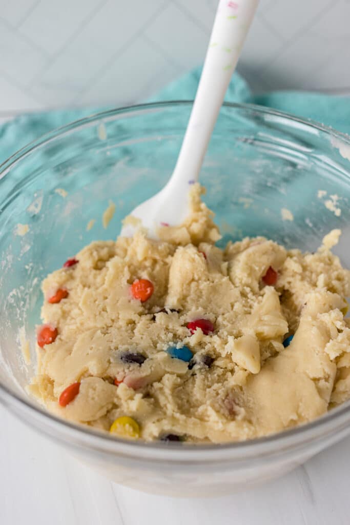 glass mixing bowl filled with M&M sugar cookie dough.