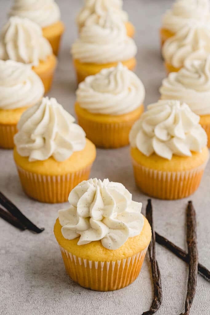vanilla buttercream piped onto yellow cupcakes.