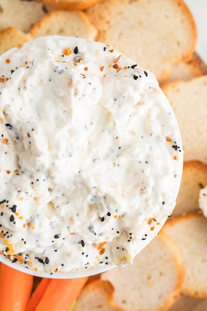 overhead shot of everything bagel dip with carrot sticks.