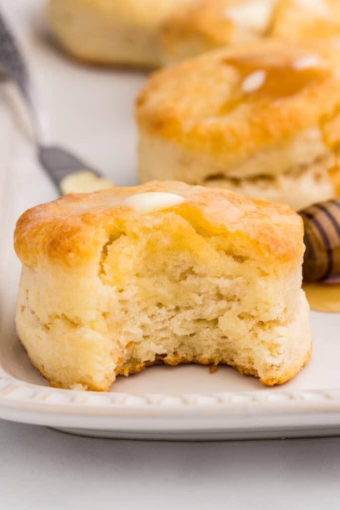 A golden biscuit with a bite taken out, showing its soft interior.