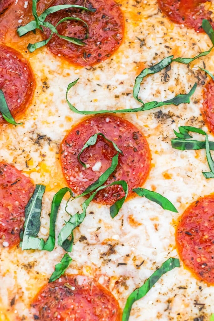 Slow cooker pizza dip surrounded by bread, cheese, sauce, and pepperoni.