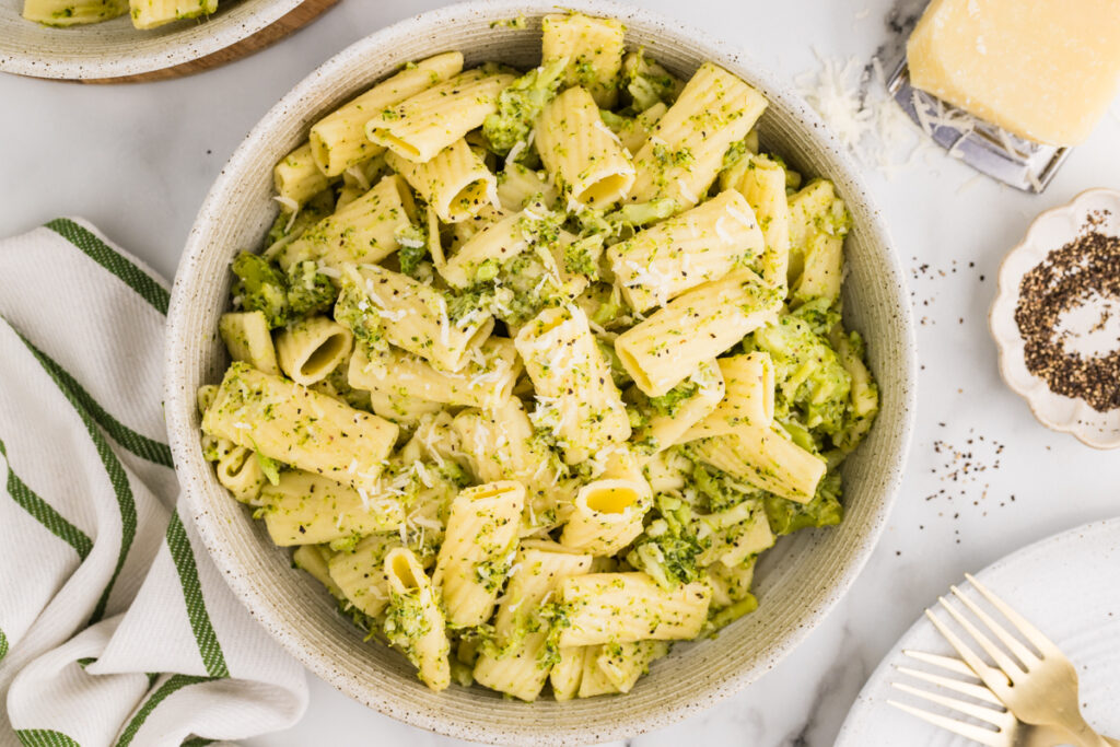 Bowl of broccoli pasta with grated cheese on top.