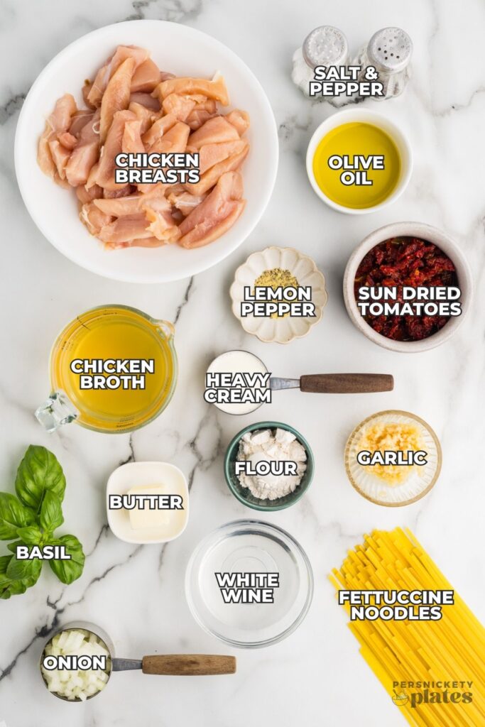 Ingredients for chicken Alfredo with labeled items on marble surface.