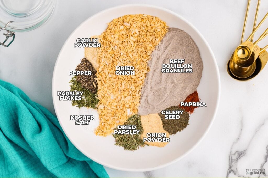 Ingredients for homemade onion soup mix arranged in a white bowl with labeled seasonings.