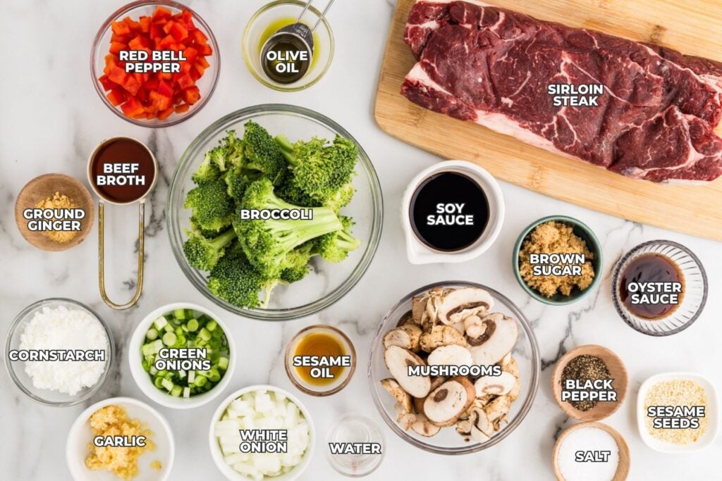 Ingredients for slow cooker pepper steak arranged on a countertop with labeled bowls and seasonings.
