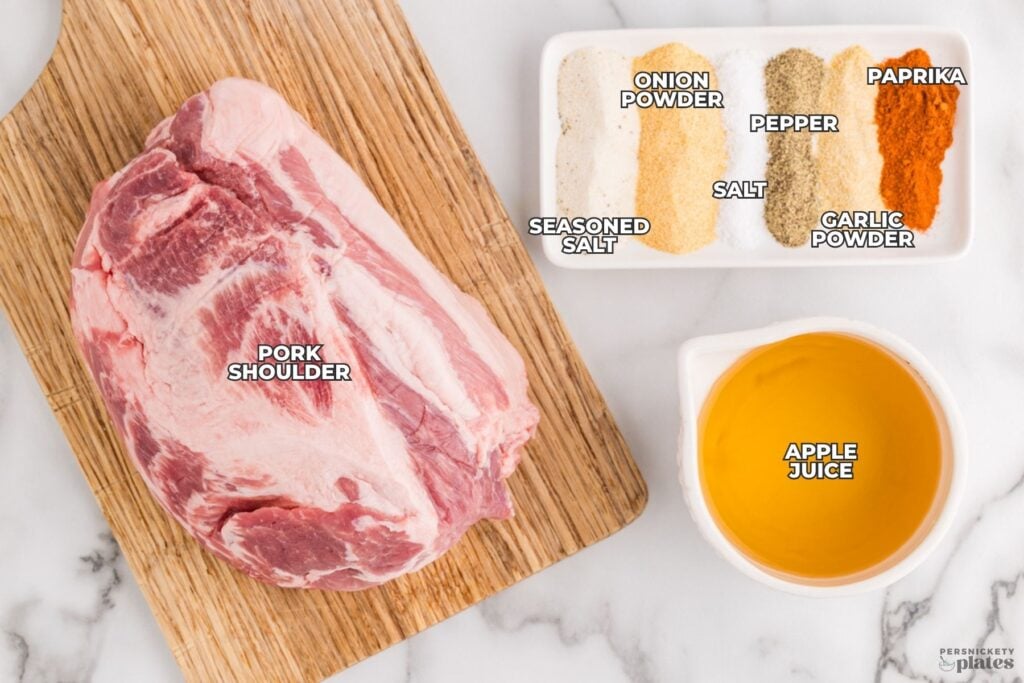 Ingredients for crockpot pulled pork arranged on a cutting board and white dishes with labeled seasonings.