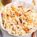 Vinegar coleslaw made with shredded cabbage and carrots in a white serving bowl.